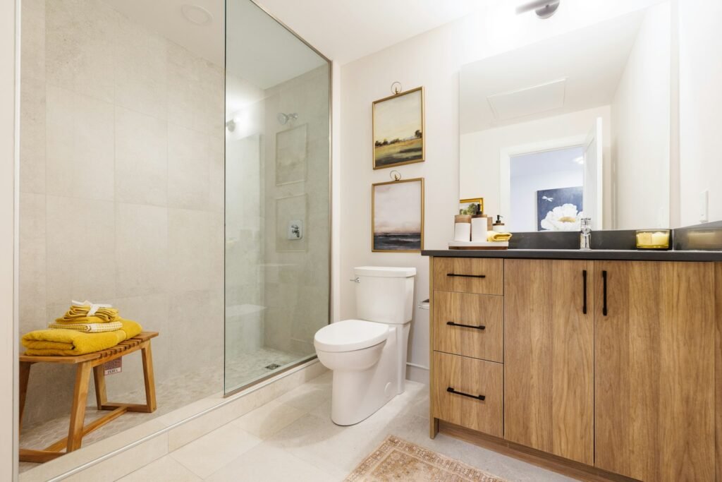 A clean modern bathroom with a wooden vanity and glass shower