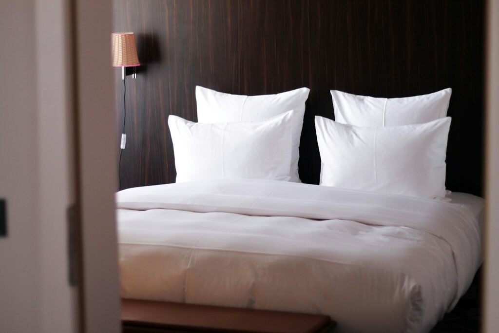 A neatly made bed with crisp white pillows