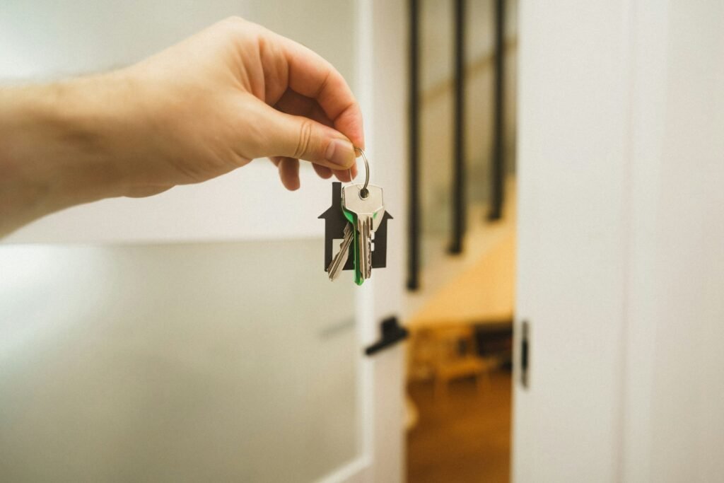 A hand holding keys at an open front door